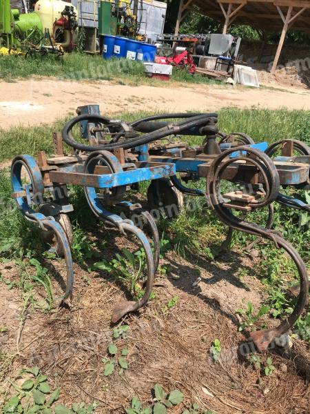 Hydraulically adjustable width spring-loaded cultivator, gruber